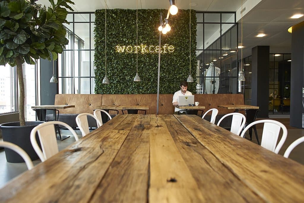 Groenwand met lichtletters in het workcafé van een kantoor