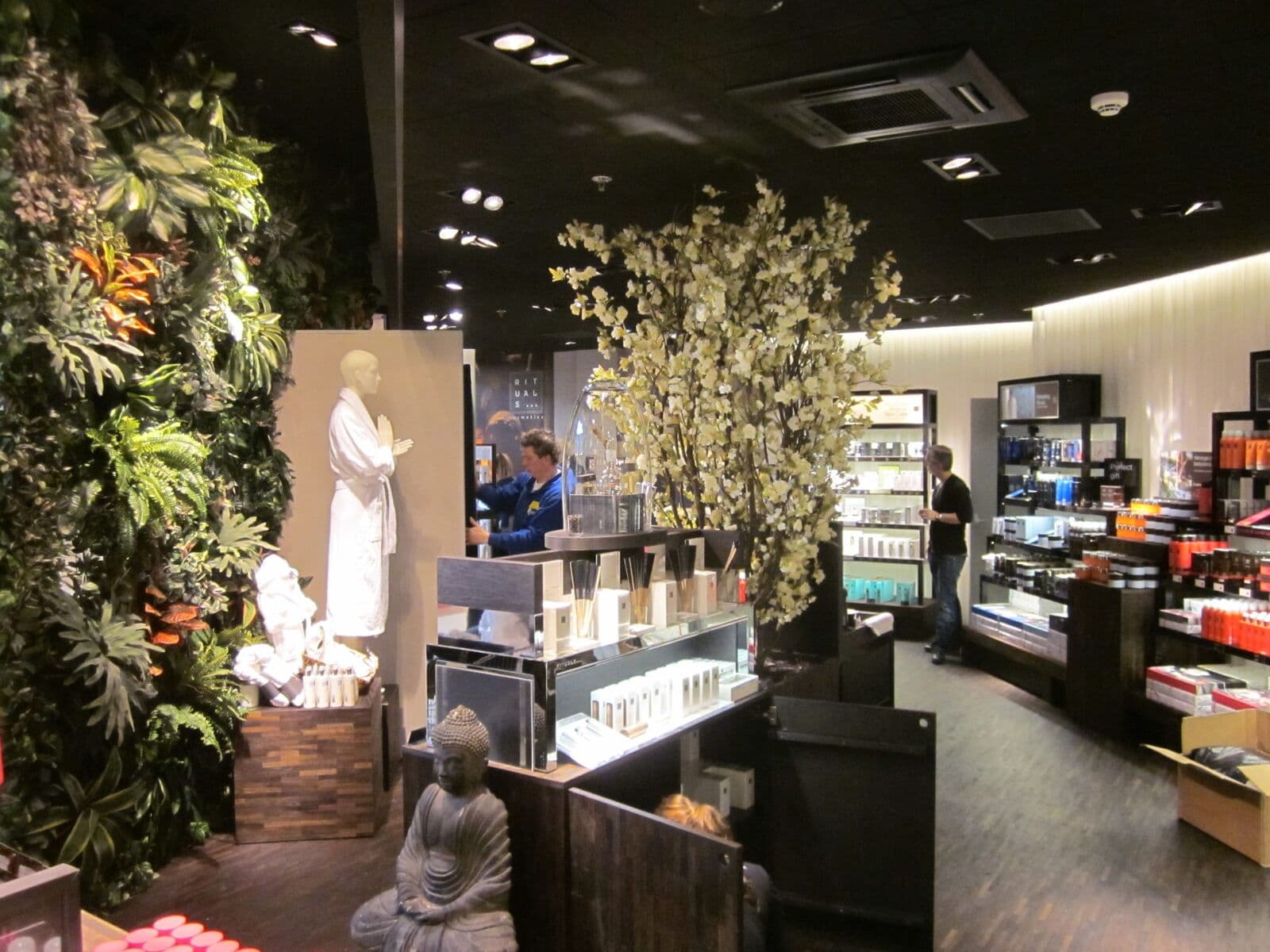 Rituals-winkel met een plantenwand en een bloesemboom